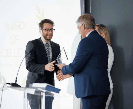 A smiling man in a suit accepts an award for PCI Compliance Solutions.